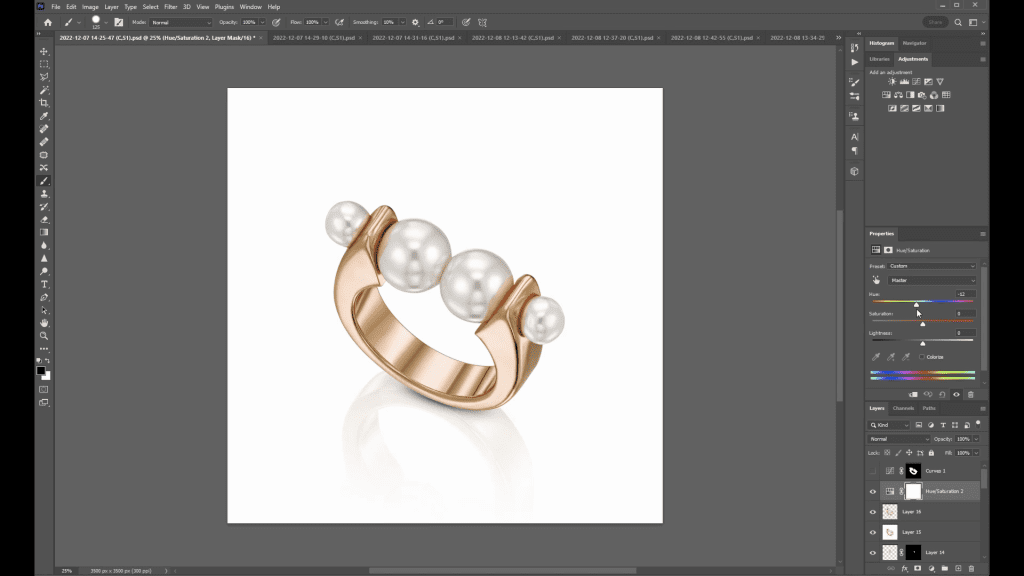 The pearl ring from the course shown in a rose gold tone in Photoshop during the Changing Colors lesson, with its reflection beneath it and the Layers panel open on the right.