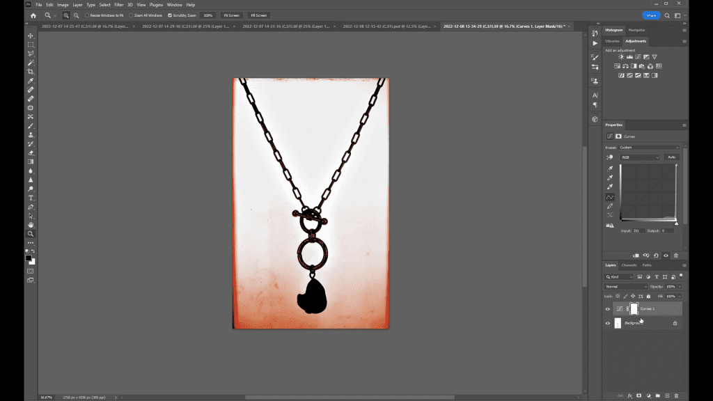 A hanging chain necklace with a black pendant on a warm gradient background, open in Photoshop during the Necklace Retouching lesson of the course.