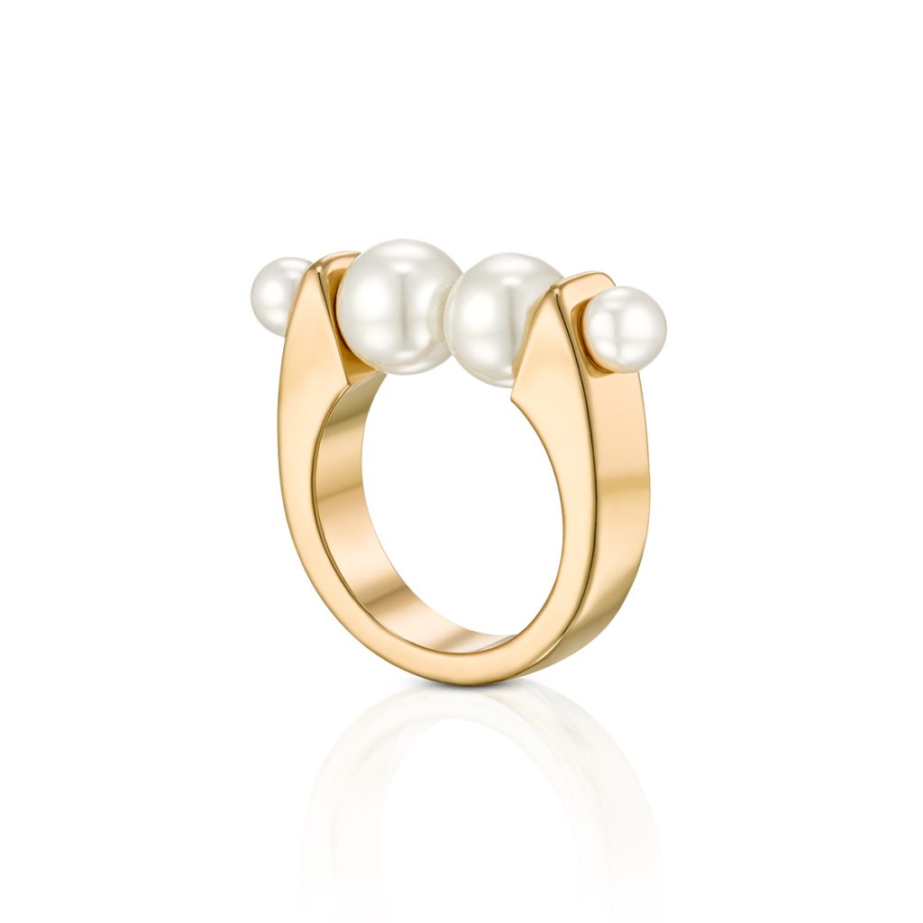 Finished image of a gold ring with three pearls standing upright in a three-quarter view on white, photographed and retouched in the course, with its reflection beneath it.
