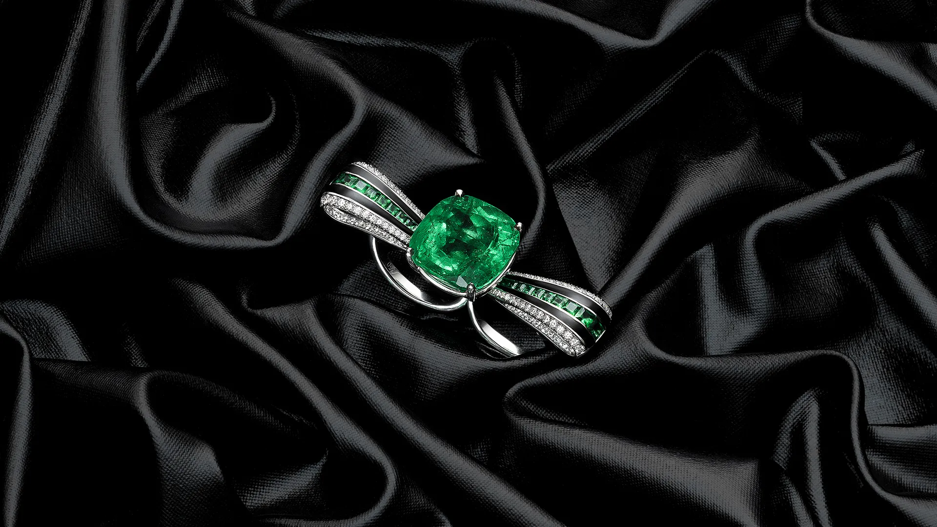 Green gemstone ring on black silk, photographed by Ivan Moshe